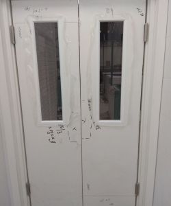 Двухстворчатая пластиковая маятниковая белая остекленная дверь