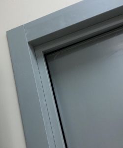 Стыковка дверной коробки и наличника на медицинской двери серого цвета